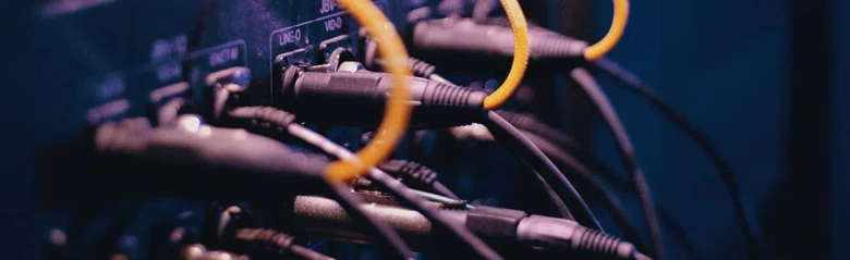 A set of cables plugged into a switch board managed by a facilities manager. 