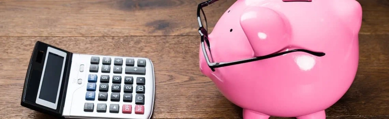 A piggy bank posing as an investment banker with its calculator and glasses