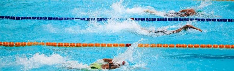 Swimmers competing in a pool during a race, showcasing a leisure centre activity.