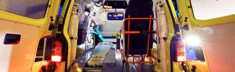 Interior view of an ambulance with medical equipment and an empty stretcher.