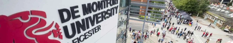 Aerial view of a crowd of people at De Montfort University with the university's sign in the foreground.