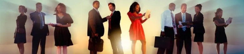 Diverse group of professional men and women in business attire with documents and digital devices, symbolizing equal opportunities in the workplace.