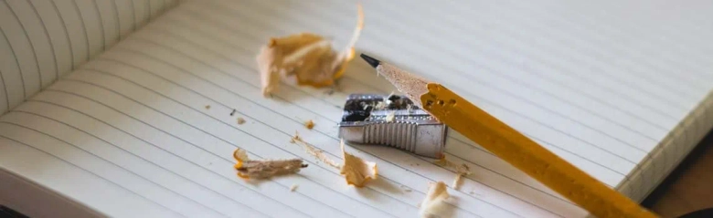 A notebook, pencil, pencil sharpener and shavings