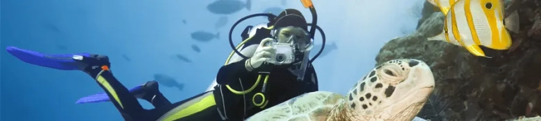 A scuba diver taking a photo underwater.