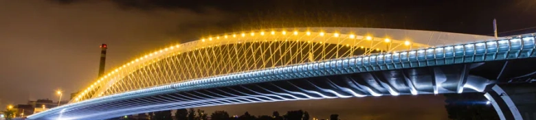 Illuminated modern bridge at night showcasing architectural design and engineering.