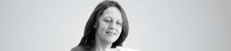 Black and white portrait of Fiona Medlock smiling, with a blurred background.