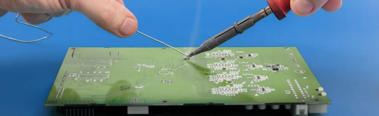 an electrical engineer soldering components to a chipboard. 