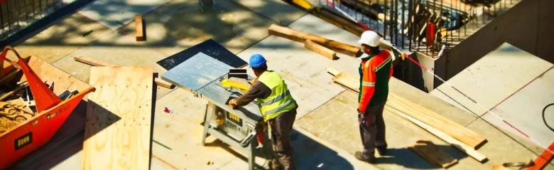 Two men working on building site.