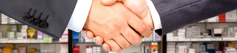 Two professionals shaking hands in front of a pharmacy counter, symbolizing alternative career paths for medical graduates.