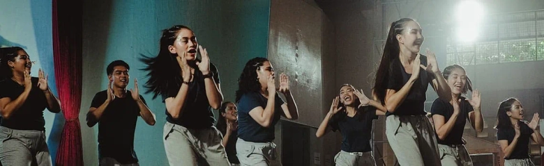 Group of people engaged in expressive dance movements in a studio setting, conveying emotion through their gestures.