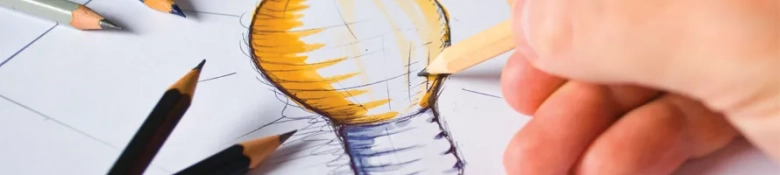 Close-up of a hand drawing a lightbulb with colored pencils, symbolizing creative thinking and ideas.