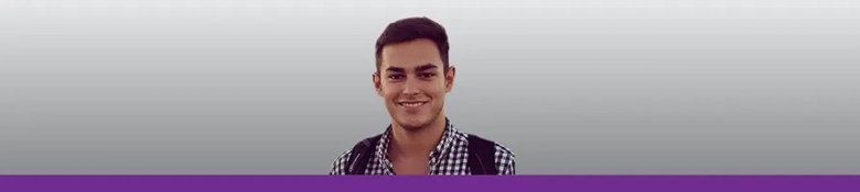 Smiling young professional with a checkered shirt against a grey background with a purple accent.