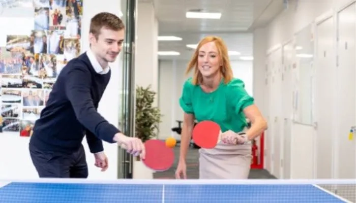 Two colleagues playing table tennis