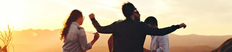 Group of friends on hill top watching sunset