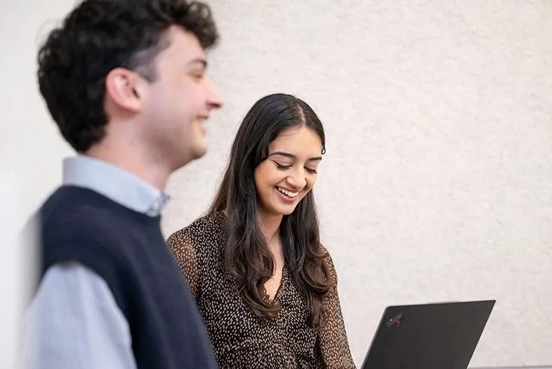 two trainees smiling while working together