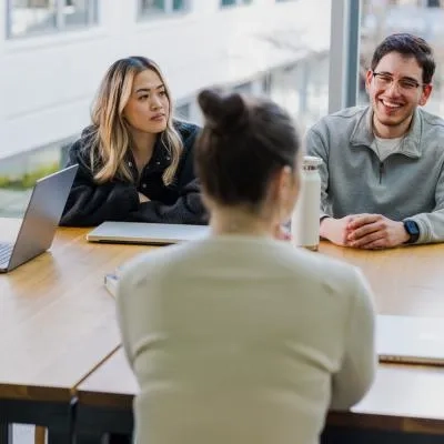 3 people sat around a table 