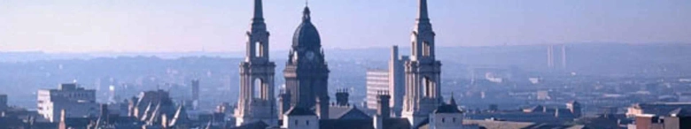 Panoramic view of Leeds skyline with prominent university buildings and clear blue sky.
