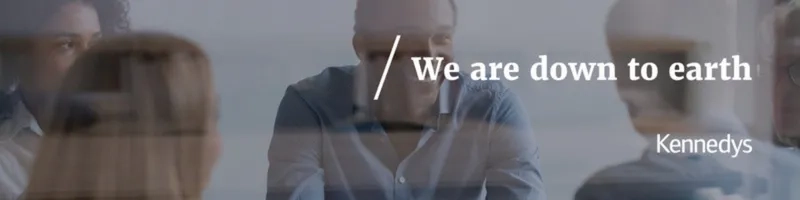 trainees speaking together at a desk with white text stating we are down to earth