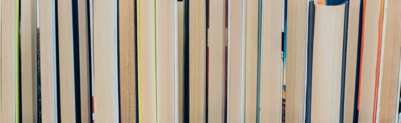 Close-up view of a variety of book spines on a shelf.