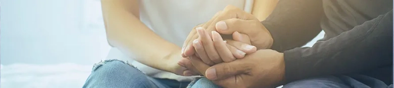 A man and a woman holding hands in support of each other: Supporting a friend struggling with mental health 