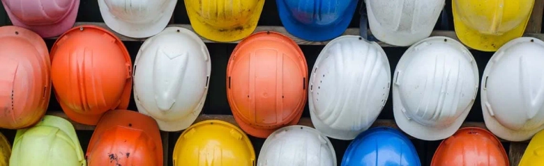 different coloured hard hat helmets lined up in rows. 