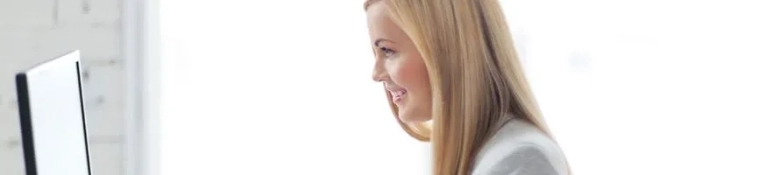 Smiling woman working at a computer in a bright office setting