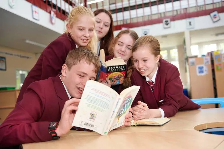 Group of children reading a Harry Potter book