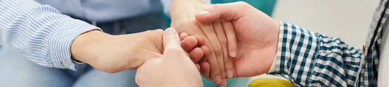 Two people holding hands, symbolising the care offered by a mental health support worker