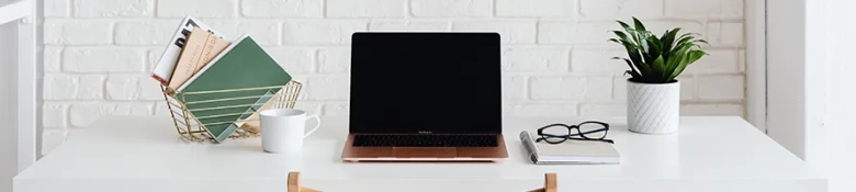 A picture of a desk, laptop and plant, ready to apply for KPMG's graduate programmes