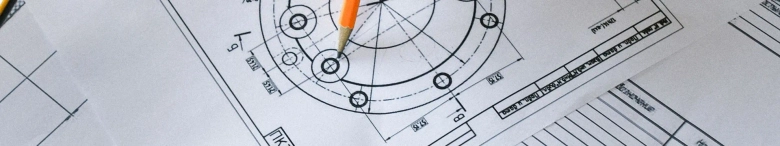 Man working with scheme on paper at a table to represent research and development engineering