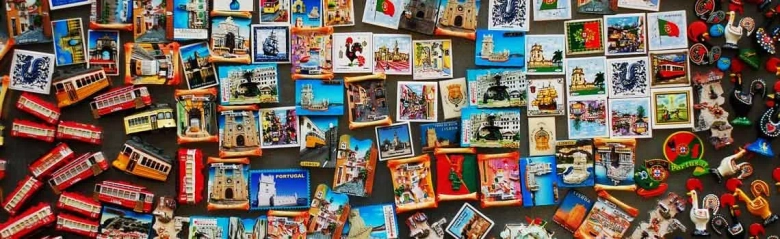 Assortment of colorful souvenir magnets from various travel destinations displayed on a surface.