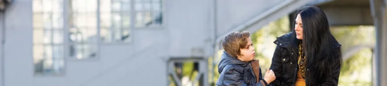 Social worker interacting with a young boy outdoors, reflecting a moment of support and guidance.