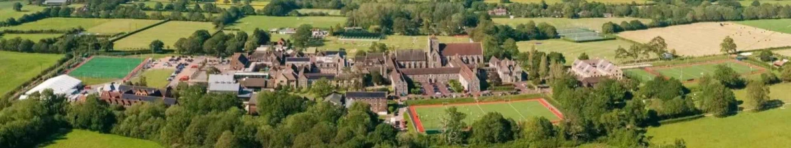 Aerial view of Hurstpierpoint College campus with sports fields, buildings, and surrounding greenery