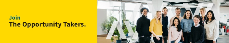 A group of nine graduate employees smiling in an office: discover what Aviva's technology roles involve