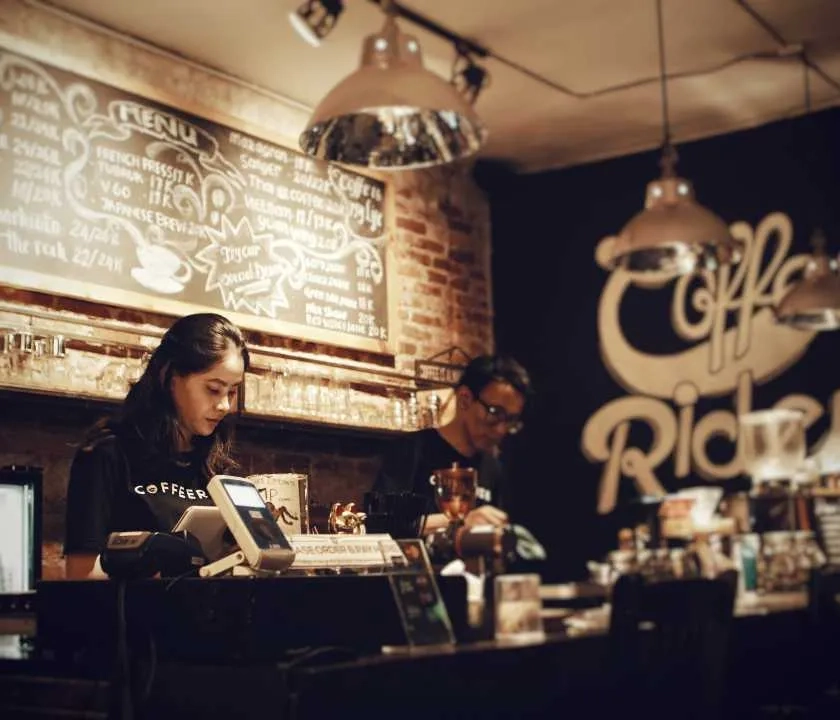 Baristas behind a counter in a coffeeshop