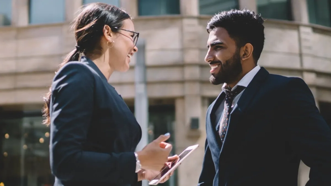 woman and man smiling at each other outside