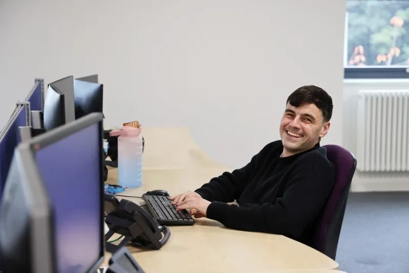 One male employee smiling at the camera