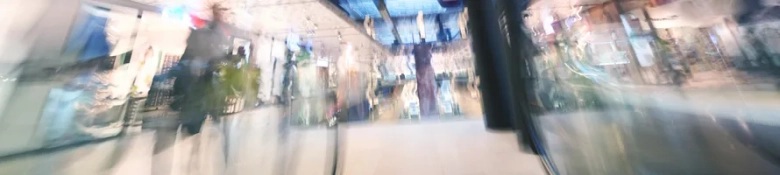 Blurred view of a shopping mall interior, representing the fast-paced environment of retail IT work.