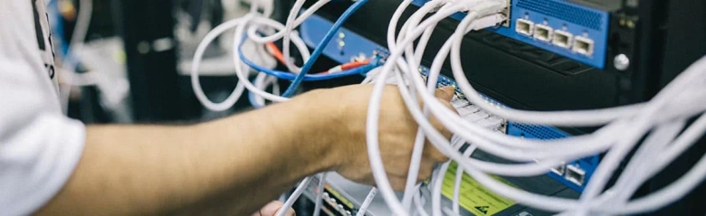 A commissioning engineer plugging cables into a machine.