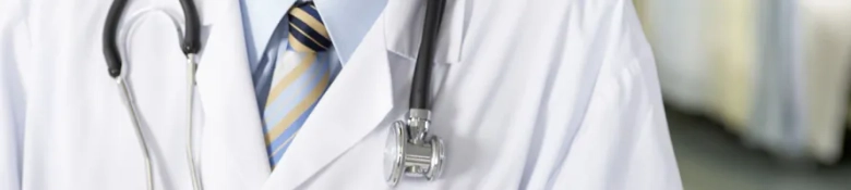 Close-up of a doctor's white coat with a stethoscope and a striped tie, symbolizing the medical profession.