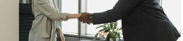 A close up of a handshake in an office environment