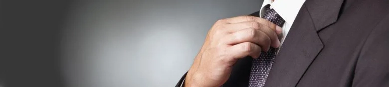 A male graduate adjusting his tie before he starts his first day at work