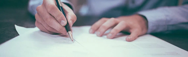 Male professional signing a document