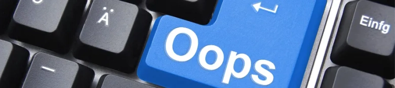 A black laptop keyboard with an oops written on a blue enter key, signalling covering letter mistakes