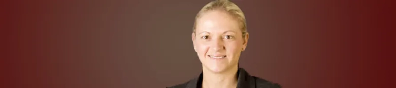 Professional headshot of Rachel Young, a barrister and pupillage panel member, smiling against a maroon background.