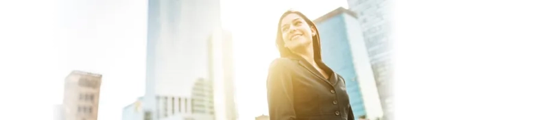 The picture depicts a young woman in front of skyscrapers