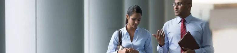 Two smartly dressed professionals negotiating while walking