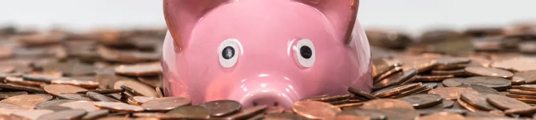 A pink piggybank looking perplexed and surrounded by coins