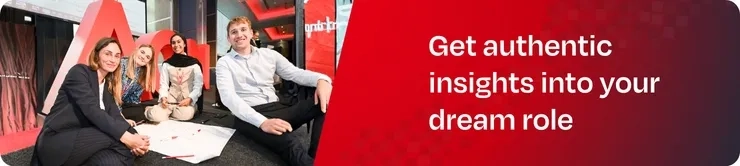 3 women, 1 man sitting down working on a posterboard next to Aon logo and red background