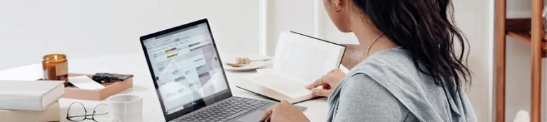 A woman using a planner application on her laptop. 